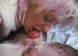 Mature blonde sucks the dog's cock and swallows a bit of sperm